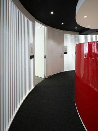 TECHTUIT CO.,LTD/【Shared hallway to office area】The hallway of the affiliate floor is designed to provide a sense for what is happening beyond the louvers. 