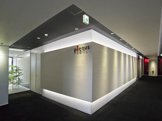 Plenus Company Limited/【Entrance area (Entrance - executive area)】Visitors are greeted in a space in which the corporate color of red leaves a strong impression