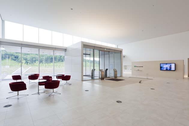 Tokyo Electron Miyagi Limited/【Entrance area】A simple entrance that is uniformly white. The bright red lobby chairs provide an accent.