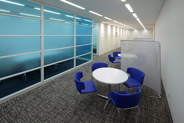 IBJ, Inc./【Entrance area】Client conference room area featuring the corporate identity color blue.