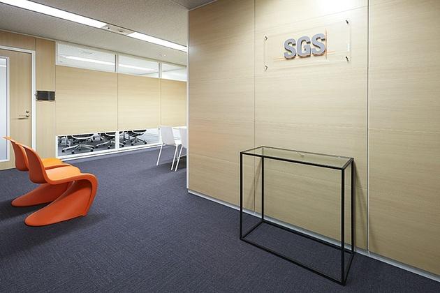 SGS Japan Inc./【5F Entrance】Chairs are finished in the orange corporate color.