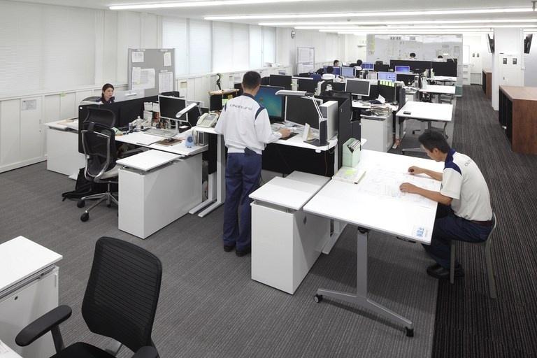 Okamura Corporation/【Work area (design)】Taking into consideration work efficiency and health factors, adjustable-height desks were used for design personnel who spend a long time at their desks preparing diagrams, etc. 
